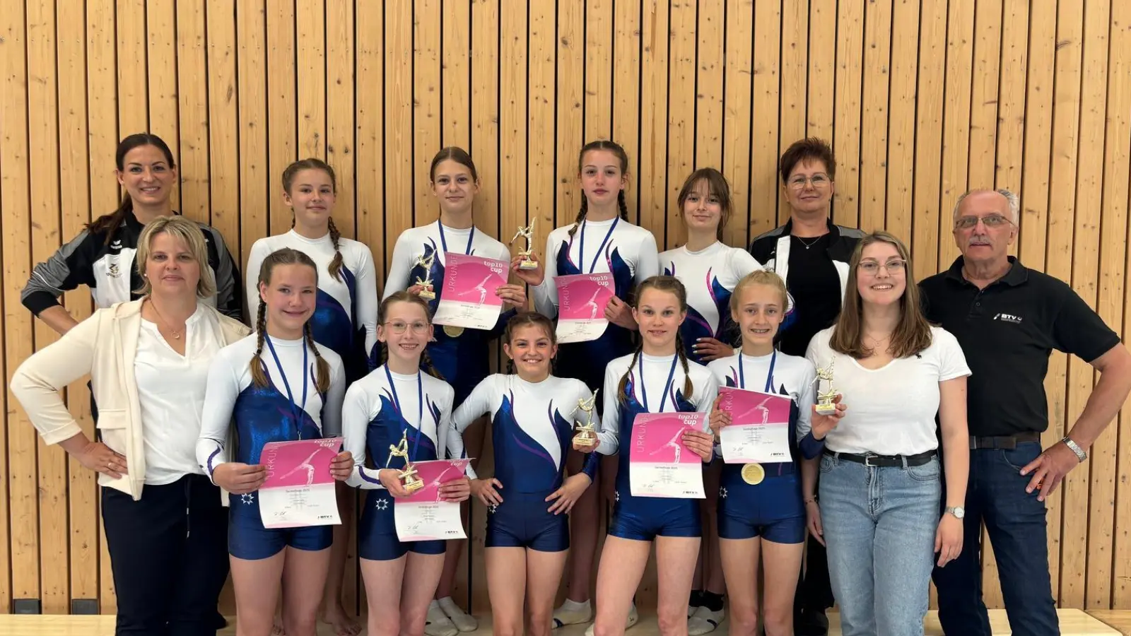 Foto der Turnerinnen mit den Trainnerinnen Iris Purucker und Sonja Grünauer (oben links und rechts) und Kampfrichterinnen Sabine Bollmann und Linda Kammerer (vorne links und rechts) sowie Spartenleiter Bernt Rose. (Bild: Sonja Grünauer)