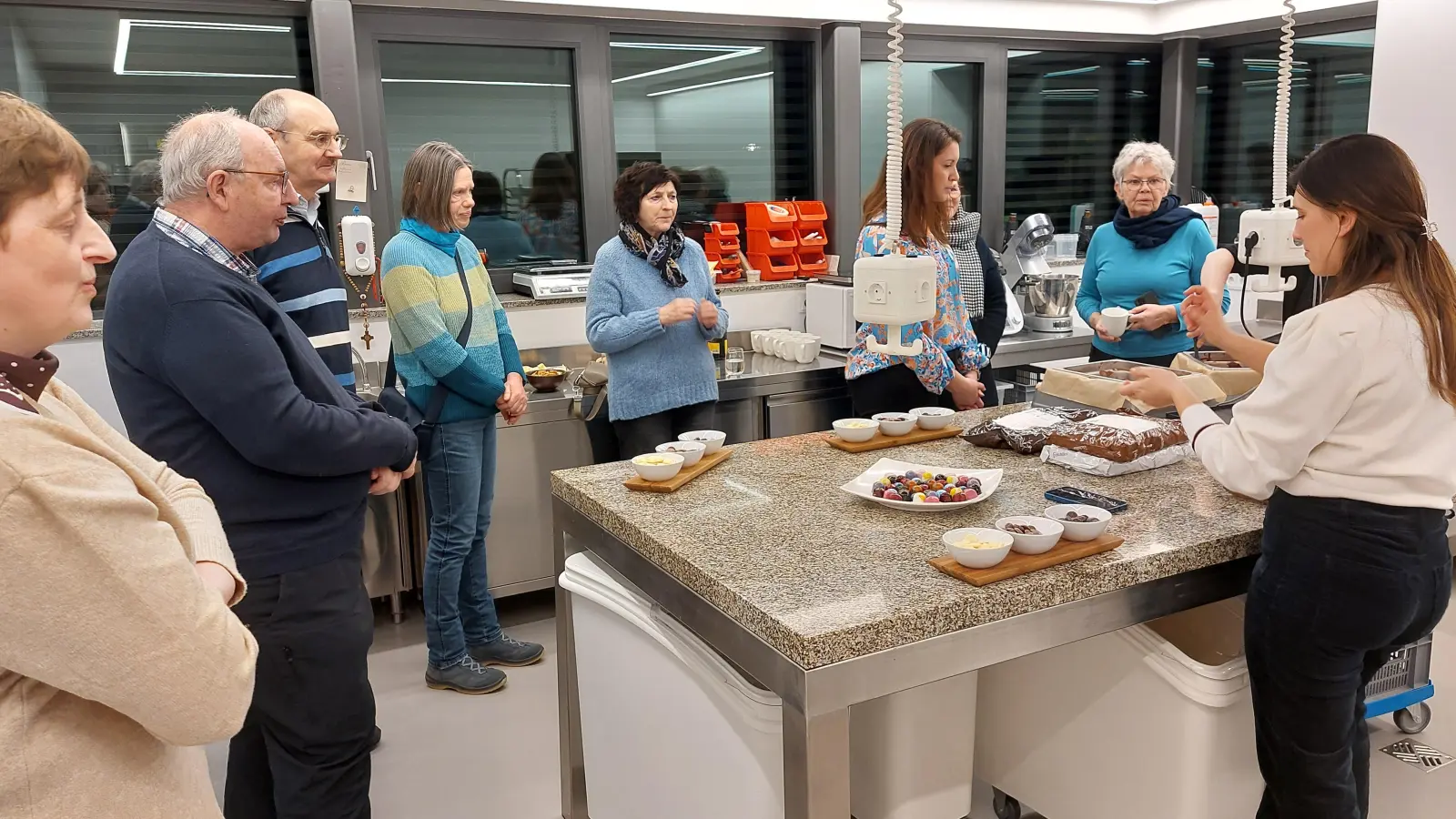 Patricia Destro Groppengiesser (rechts) erklärt den vlf-Gästen mit Geschäftsführer Gerhard Gradl (Dritter von links) die Herstellung von Pralinen (Bild: Wolfgang Wenisch)