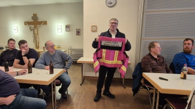 Anschaulich und praxisnah: Dekan Michael Hirmer, Leiter der PSNV im Landkreis Schwandorf, zeigte den Zuhörern im Pfarrsaal die pinkfarbene Einsatzweste der PSNV-Leitung. Sie macht die Helfer bei Einsätzen sofort erkennbar. (Bild: Georg Hirmer)