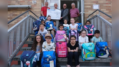 Angehende ABC-Schützen aus Flüchtlingsfamilien durften bei der Amberger Tafel bunte Schulranzen nach ihrer Wahl aussuchen. Zur Finanzierung der Rucksäcke übergaben Vertreter des Lions-Clubs Amberg-Sulzbach eine Spende in Höhe von 1.500 Euro an Bernhard Saurenbach, den Vorsitzenden der Amberger Tafel (hinten Zweiter von links). (Bild: Hubert Uschald)