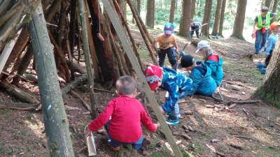 Die Kinder sammeln Stöcke und Naturmaterialien und bauen sich ein Haus. (Bild: Julia Röckl)