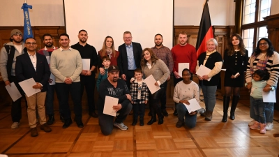 Strahlende Gesichter bei der ersten Einbürgerungsfeier des Jahres 2026 im Kleinen Rathaussaal: OB Michael Cerny (Zweite Reihe, Siebter von links) im Kreis der neuen Staatsbürgerinnen und Staatsbürger. (Bild: Thomas Graml)