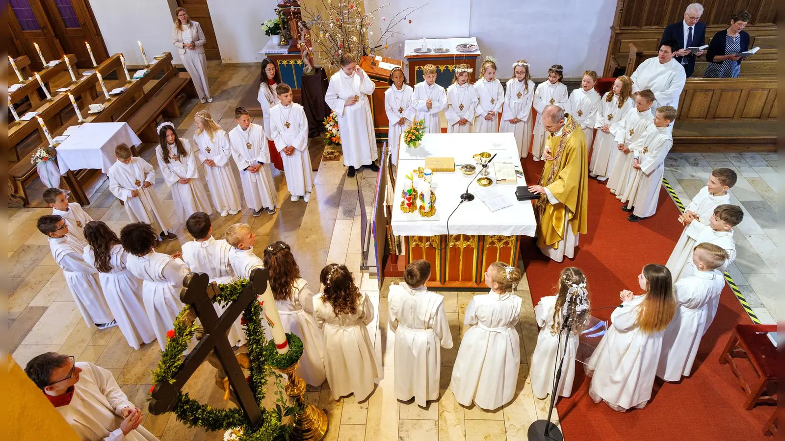 Zum ersten Mal bekamen die um den Altar versammelten 31 Mädchen und Buben die Hl. Kommunion, von Pf. Johann Hofmann. (Bild: Photograf Gerd Huster)