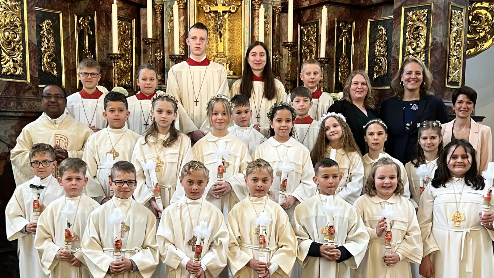 Stadtpfarrer Hrudaya Madanu (links) spendete 16 Kindern in der Stadtpfarrkirche Vilseck das Sakrament der ersten heiligen Kommunion. Er dankte besonders den Tischmüttern Kristina Götz, Katharina Kreuzer, Beate Stiller und Anna Metz, die die Kinder gut auf den großen Tag vorbereitet hatten. (Bild: Andreas Kreuzer)