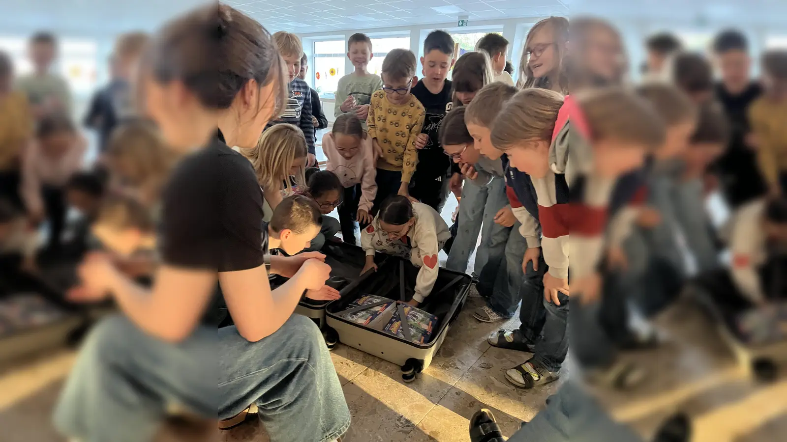 Schüler beim Öffnen des Koffers mit den Lektüren. (Bild: Simone Völkl)