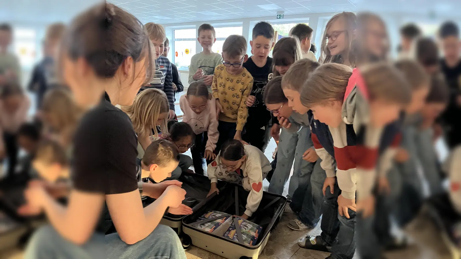 Schüler beim Öffnen des Koffers mit den Lektüren. (Bild: Simone Völkl)