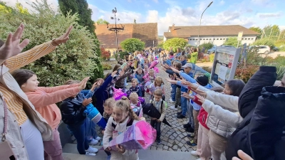 Die Mädels und Jungs der 2 bis 4 Klasse empfingen die Erstklässler im Spalier mit Gesang. (Bild: Karl Ziegler)