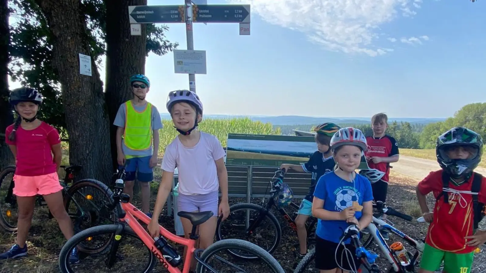 Pause mit Aussicht: Auf der Weißenberger Höhe waren es nach der Panne nur noch sechs – doch die Laune blieb bestens. Der 13-jährige Luis (2. v. links) unterstützte Heidi Hiltel tatkräftig und sorgte in seiner Warnweste für die nötige Sicherheit. (Bild: Heidi Hiltel)