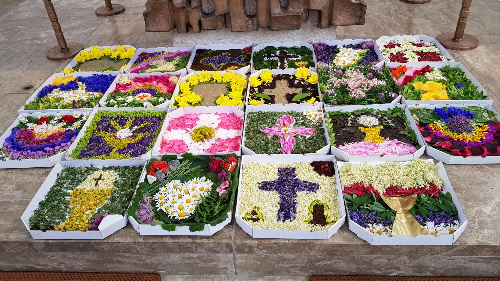 Erstmals Blumenteppiche der Erstkommunionkinder im Pizzakarton zu Fronleichnam. (Bild: Peter Garreiss)