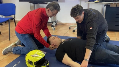Ausbilderin Kerstin Ehemann rechts) demonstriert zusammen mit Kursteilnehmer Manfred Seibert die fachgerechte Abnahme des Sturzhelmes bei einem verunglückten Motorradfahrer. (Bild: Hans Rachwalik)