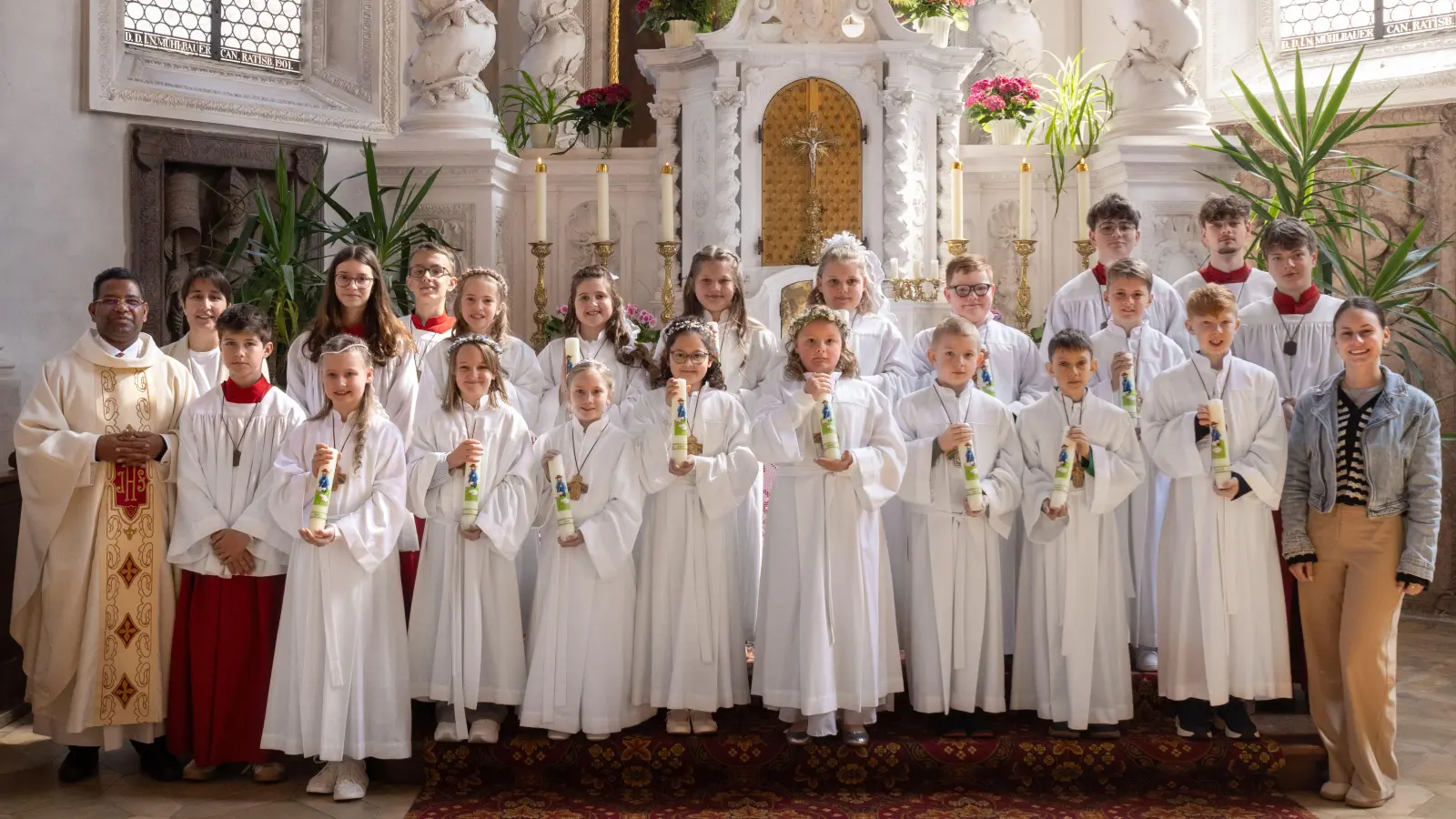 14 Erstkommunionkinder zusammen mit Pfarrer P. Georg Parampilthadathil, ihrer Klassenlehrerin Frau Spring, der Religionslehrerin Reinhilde Bodensteiner, sowie dem liturgischen Dienst. (Bild: Sandra Dobmeier ? FotoGen)