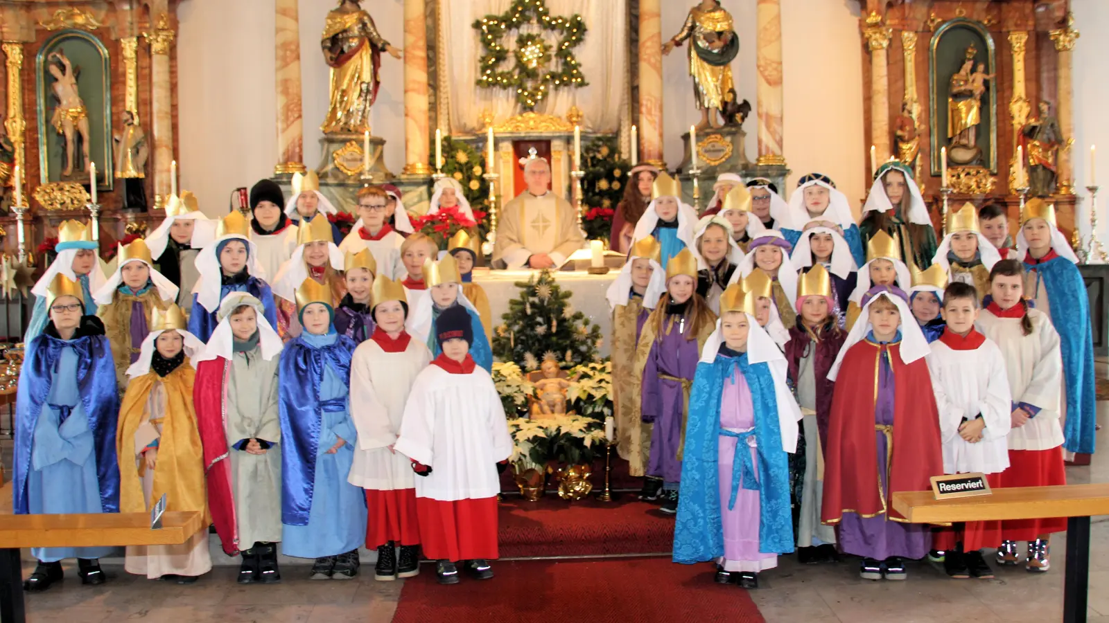 Die Sternsingergruppen bei der Aussendungsfeier mit Pfarrer Norbert Große. (Bild: Johann Bauer)