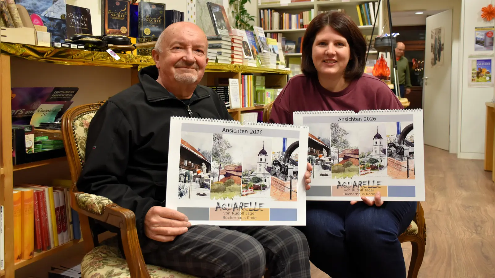 Der Tirsdhenreuther Aquarellmaler und KVT-Mitglied Rudolf Jäger (im Bild mit Buchhändlerin Stefanie Teicher von der Buchhandlung Rode) hat auch in diesem Jahr wieder seinem Verein, dem Kunstverein Tirschenreuth, seinen neuesten Kunstkalender 2026 vorgestellt. Vorsitzende Petra Schicker ist begeistert.  (Bild: Ulla Britta Baumer)