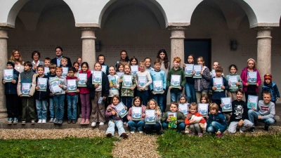 Am Sommerferien-Leseclub 2026 teilnehmende Kinder mit ihren Urkunden. Im Hintergrund Kinderbuchautorin Anna Ludwig, 1. Bürgermeister Florian Reger und Büchereileiterin Irmi Sittl. (Bild: Kurt F. Stangl)