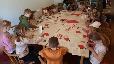 Viele fleißige Kinder basteln eine Muttertagsgirlande beim Bücherei-Nachmittag.  (Bild: Margit Dobmeier)