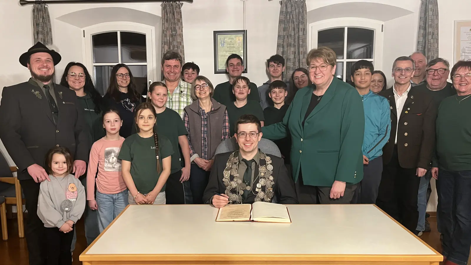 Thomas Zimmermann mit Familie und den Vereinskameraden beim Eintrag ins Goldene Buch der Gemeinde (Bild: Michael Forster)