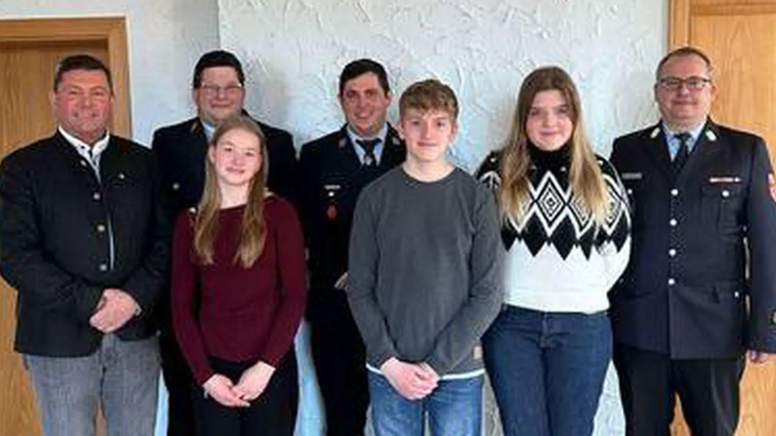 Bürgermeister Rainer Rewitzer (links), 1. Vorsitzender Maximilian Wolf (2. von links) begrüßen die Neumitglieder Johanna Landgraf, Jakob Landgraf und Magdalena Grötsch (vorne von links). Auch Kommandant Johannes Siller und Kreisbrandmeister Matthias Schmidt (hintere Reihe) freuen sich über die neuen aktiven Mitglieder. (Bild: Fabiola Fuchs)