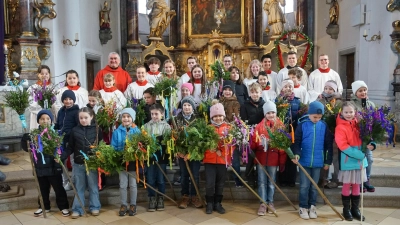 Die Kommunionkinder mit ihren Palmbuschen sowie die Ministranten und Pfarrer Alfons Kaufmann nach der Palmsonntagsfeier. (Bild: Martin Uschold)