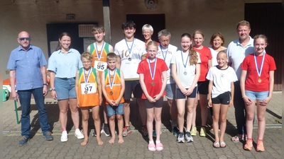 Auf dem Bild alle Medaillengewinner der Stadtmeisterschaft im Straßenlauf, sowie Stadtverbandsvorsitzender Peter Haibach (links), TuS Präsidentin Carmen Reif (2.v.l.) und Bürgermeister Stefan Grillmeier (2.v.r.) (Bild: Anton Bauernfeind)