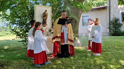 Pfarrer Adam Karolczak spendete am letzten Fluraltar unter den Kastanienbäumen beim Pfälzerhof den eucharistischen Segen. Ministranten und Gläubige begleiteten die traditionelle Prozession durch die Fluren von Waidhaus. (Bild: Josef Kleber)