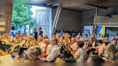 Der Schnappschuss zeigt einen Ausschnitt von der geräumigen Konzert-Scheune mit den teilnehmenden Gruppen und den Zuschauern. Die Akteure sind im Rondell postiert. (Bild: Karl Wildenauer)