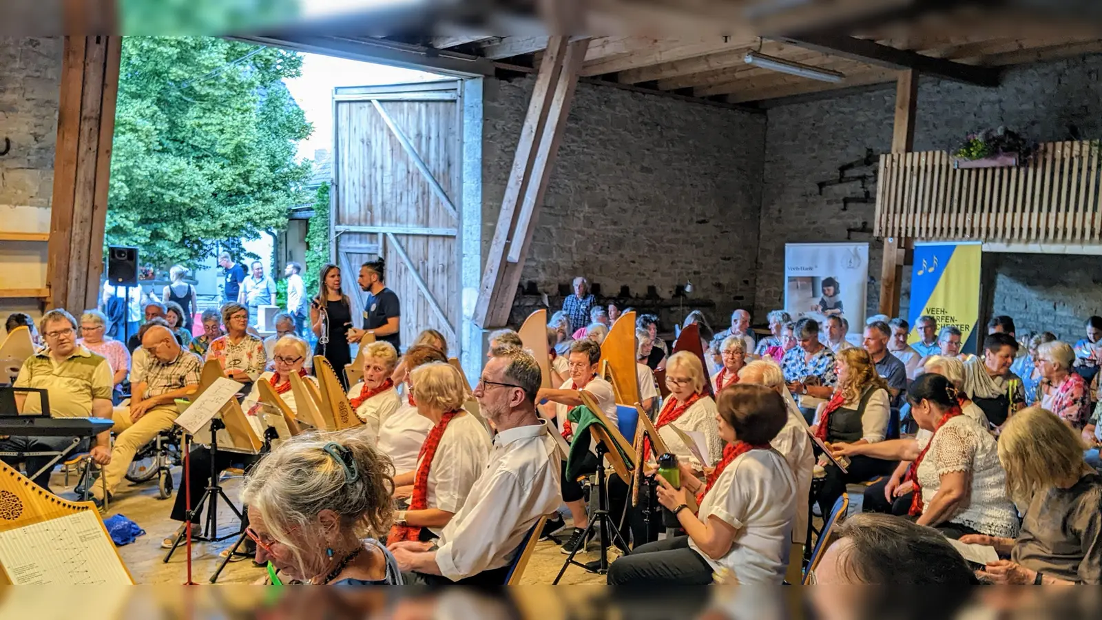 Der Schnappschuss zeigt einen Ausschnitt von der geräumigen Konzert-Scheune mit den teilnehmenden Gruppen und den Zuschauern. Die Akteure sind im Rondell postiert. (Bild: Karl Wildenauer)