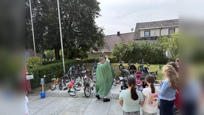 Pfarrer Dr. Dr. Matthias Nowotny segnet die Fahrräder, Tretroller und Bobbycars. (Bild: Jutta Meier)