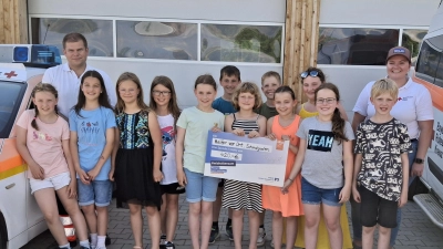 Stolz übergeben die Erstkommunionkinder aus Trisching und Rottendorf den Spendenscheck an den HvO-Dienst für das Einsatzfahrzeug.  (Bild: Sonja Pröls)
