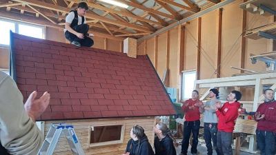 So ist es Tradition am Bau: Gideon Liebe sagt vom Dach des Kinderspielhauses aus den Richtspruch auf. Jetzt wird das Häuschen unter 47 Kindergärten verlost. (Bild: Hirsch)