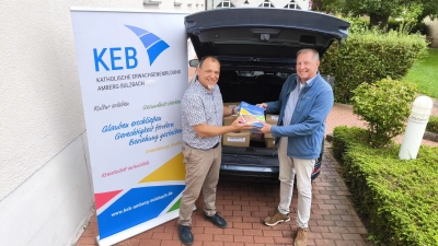 Als Startschuss für das neue Bildungsprogrammhalbjahr übergibt der Leiter der regionalen KEB Amberg-Sulzbach, Christian Irlbacher (li.), eine Fuhre neuer KEB-Programmhefte an Bildungsrat-Mitglied und KEB-Delegierten Richard Ebner (re.), der die Verteilung im Sulzbacher Raum übernimmt. (Bild: Christian Irlbacher)