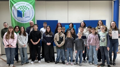 Die Landgraf-Ulrich-Schule Pfreimd erhält erneut den Titel „Umweltschule”. Vertreter der Schülerschaft, Rektorin Silke Schmid, Bürgermeister Richard Tischler und beteiligte Lehrkräfte präsentieren die Urkunde und die Fahne. (Bild: Jasmin Ulrich)