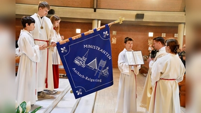 Die neue Ministrantenfahne der Pfarrei Aschach-Raigering, ein sichtbares Zeichen des Glaubens und der Verbundenheit, erhält ihre Weihe durch Kaplan Marvin Schwedler. (Bild: Alfred Schorner)