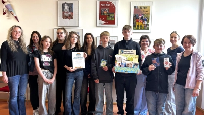 Die Leiterin der Fairtrade-AG, Heidi Riedel (2.v.l.), und Schulleiterin Irene Sebald (4.v.r.) freuen sich zusammen mit Schülerinnen und Schülern sowie weiteren Lehrkräften über die Rezertifizierung der Lobkowitz-Realschule als Fairtrade-School. (Bild: Tobias Neubert)