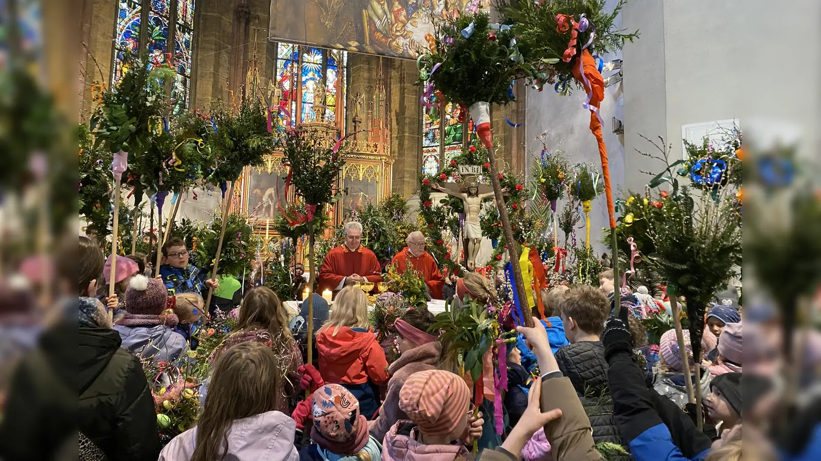 Ein farbenfrohes Bild gaben die vielen Kinder und Jugendlichen mit ihren Palmbuschen ab, als sie sich beim Gottesdienst um den Altar versammelten. (Bild: Raphael Haubelt)