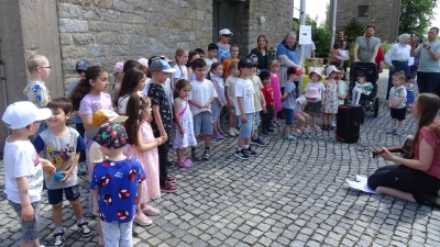 Die Kinder des Kindergartens Herz Jesu eröffneten mit einem Lied die „Bunte Wiese“, rechts Leiterin Fabienne Heining (Bild: Alfons Prechtl)