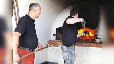 Markus Leipold (direkt am Backofen) und Frank Melzer sorgten für frisch zubereitete Pizzas und Zwiebelkuchen. (Bild: Norbert Weis)