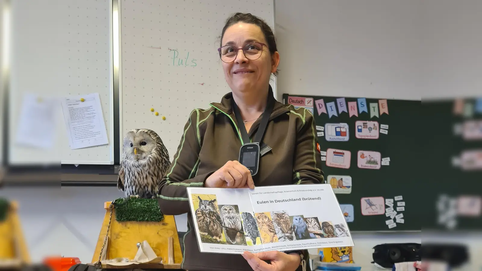 Naturkunde hautnah: Michaela Domeyer erklärt die heimische Eulenwelt, während Botschafterin Birke aufmerksam das Klassenzimmer im Blick behält. (Bild: Johannes Bradtka)