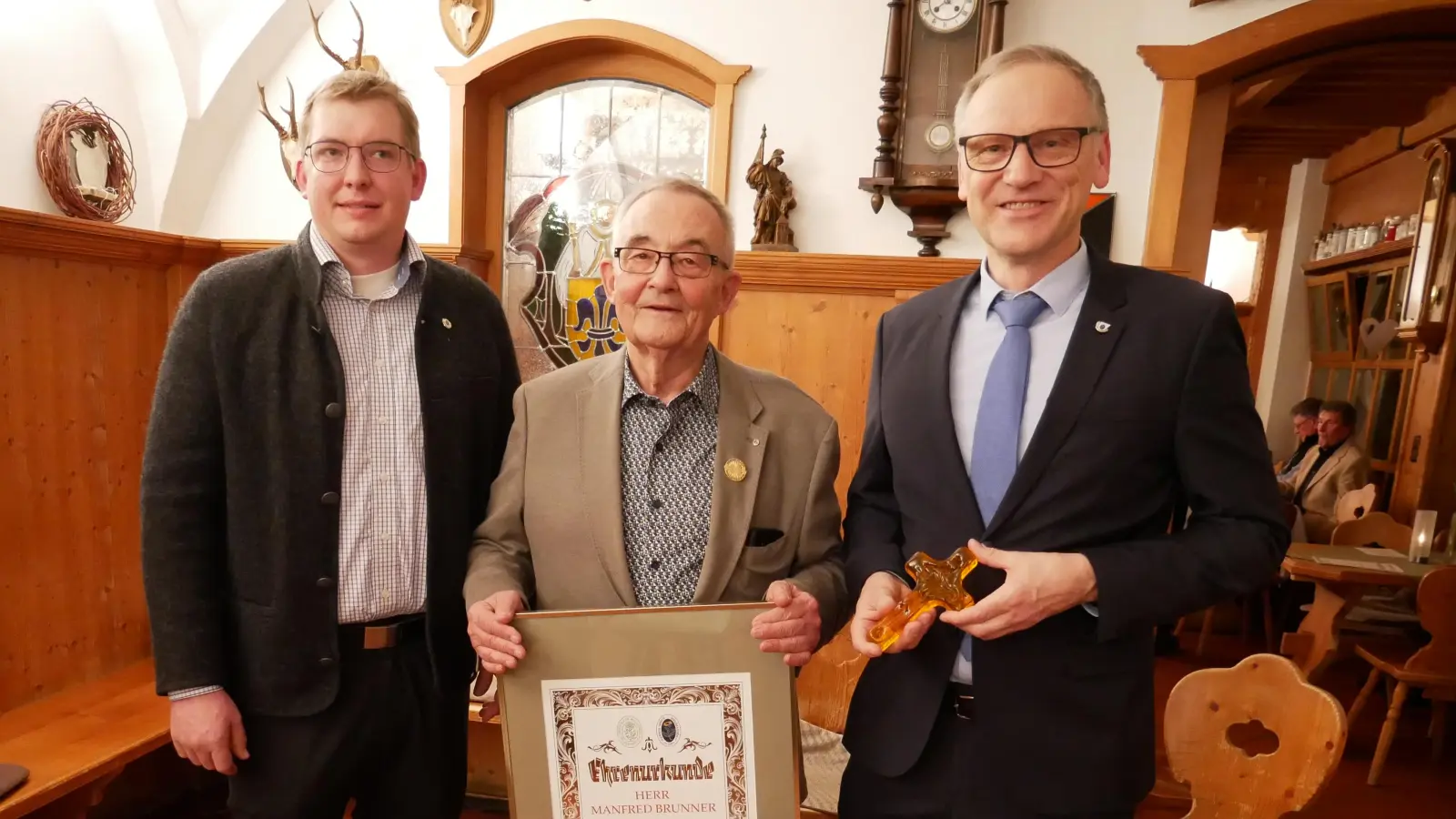 Vorsitzender Michael Fortelny (links) und Erster Bürgermeister Bernd Sommer (rechts mit dem Franziskuskreuz aus der Glashütte Lamberts) mit dem zum Ehrenvorsitzenden des Gerwig-Kreises ernannten Manfred Brunner. (Bild: Hermann Müller)