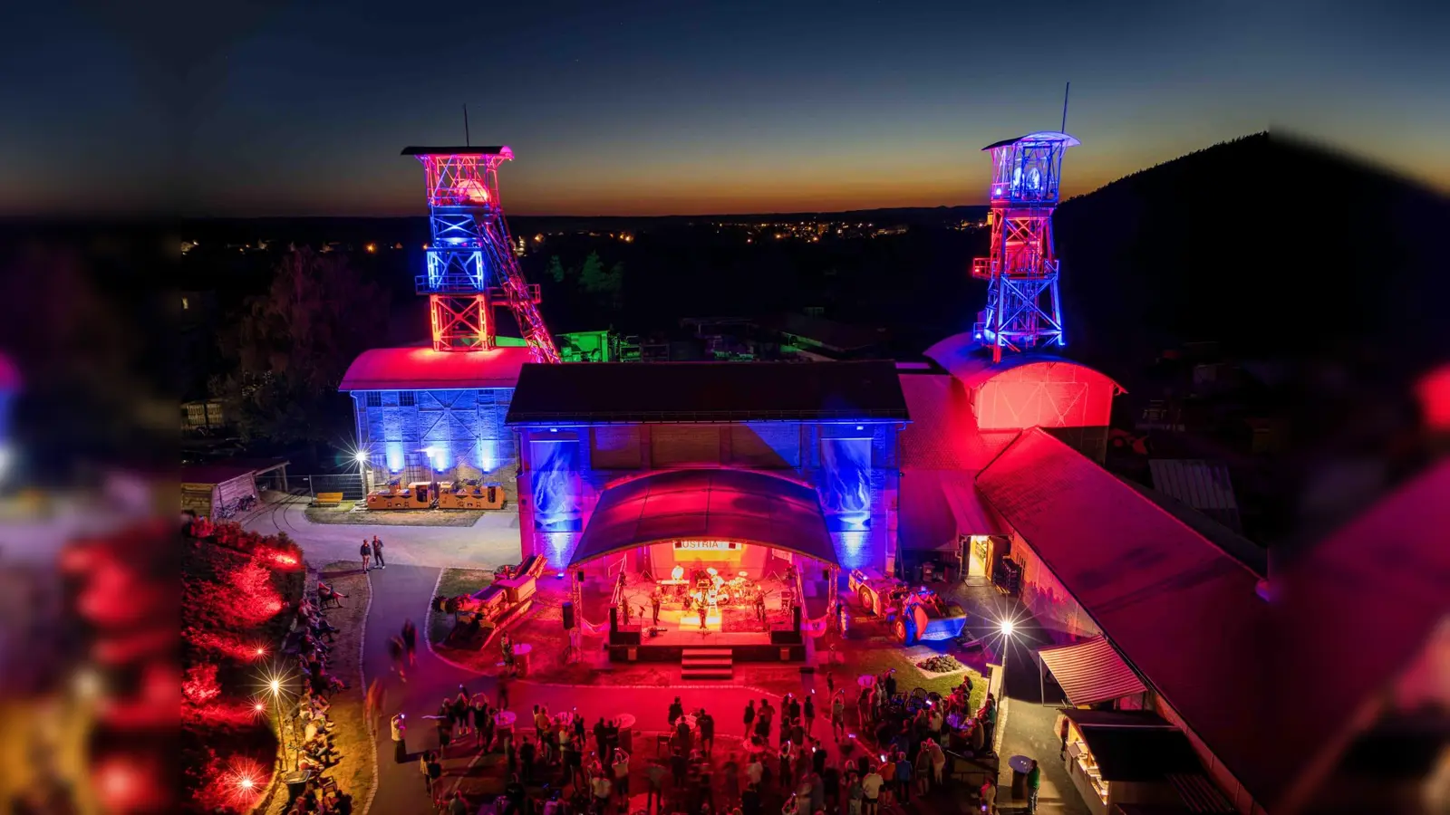 Das Classic-Rock-Festival G:O:A findet auf dem Gelände des Bergbaumuseums Maffeischächte statt. Neben der Bühnenbeleuchtung werden in der Dämmerung auch die Fördertürme illuminiert. (Bild: Michel Grüner / Förderverein Maffeispiele)