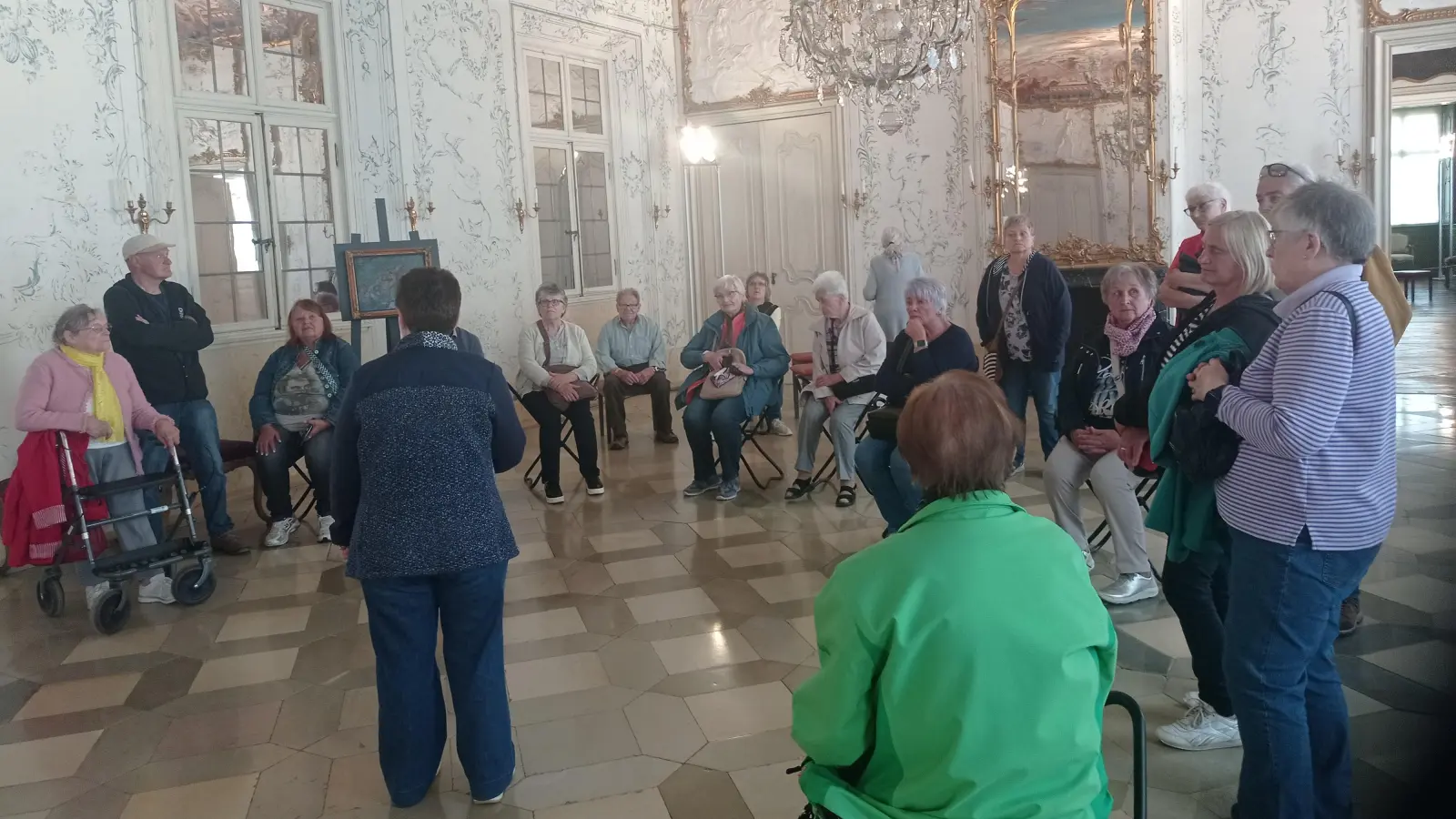 Ein Teil der Besuchergruppe des Wandervereins Kemnath lauscht im Weißen Saal des Schlosses Seehof den Ausführungen der Schlossführerin (Bild: Anton Heindl)