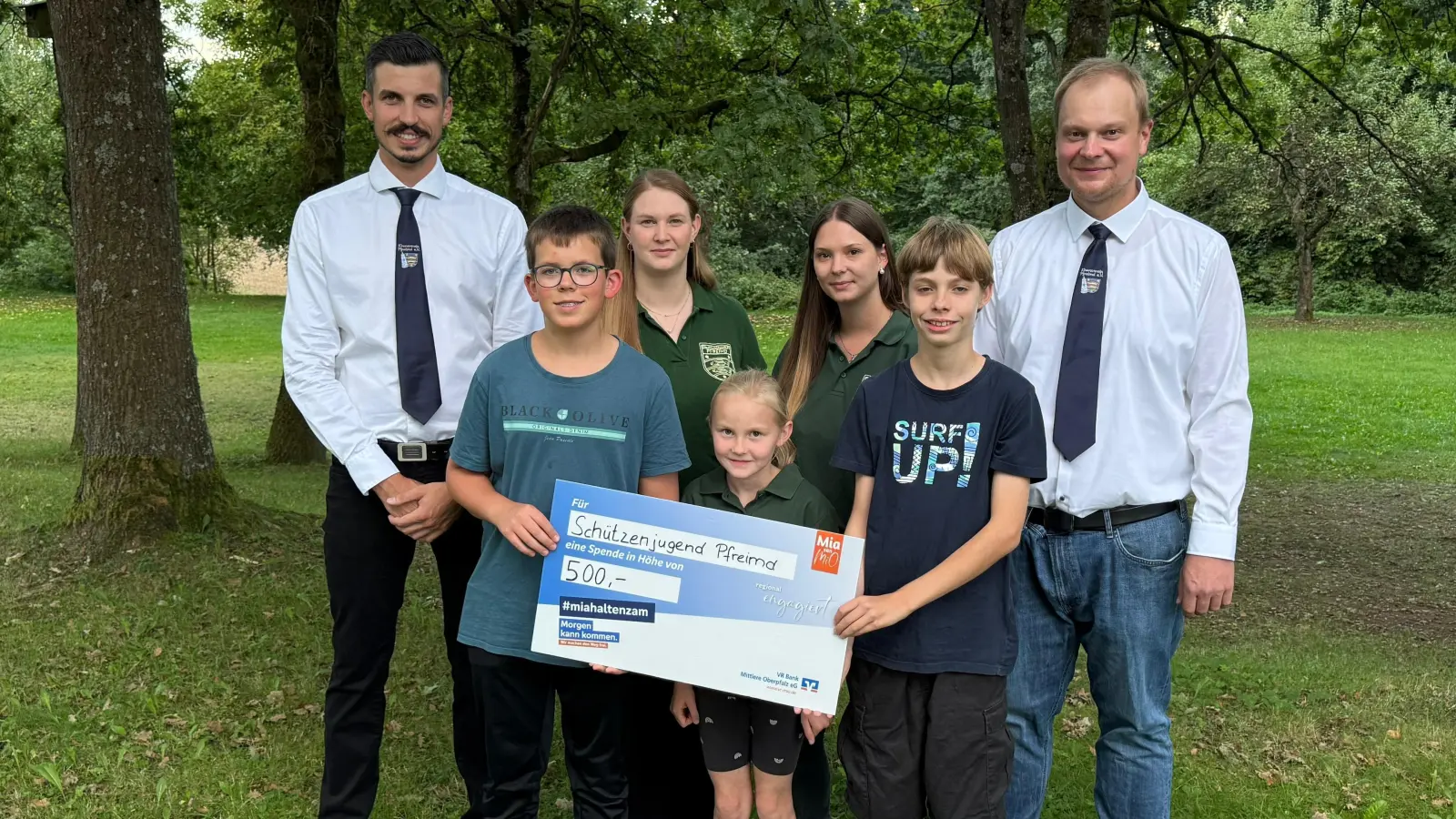 Vorstände des Kirwavereins Andreas Igl (links) und Christian Maier (rechts). In der Mitte die Jugendleiterinnen der Schützen, Julia Lindner und Katharina Irlbacher, im Vordergrund präsentiert ein Teil der Schützenjugend stolz den Spendenscheck. (Bild: Theresa Stubenvoll)