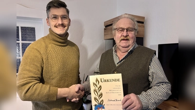 Ferdinand Heinrich (rechts) ist seit fünf Jahrzehnten Mitglied im Ski-Club Tirschenreuth. Früher war er sowohl auf Schnee als auch auf Gras mit Skiern unterwegs. Vorsitzender Alexander Schirmer gratulierte ihm nun zum Jubiläum. (Bild: Beate Heinrich)