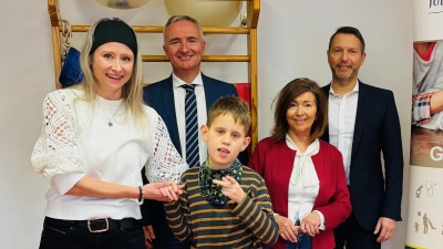 (v.l.n.r.): Nina Halbeck (Bereichsleitung Kindheit und Jugend), Dr. Harald Schwartz (Vorstandsmitglied der JRM-Stiftung), Jutta Heindl (Mitglied des Stiftungskuratoriums) und Lebenshilfe-Vorstandsvorsitzender Bernhard Vahle ließen sich die Funktionsweise der Vibrationsplatte von Schüler Philipp (Mitte) zeigen. (Bild: Mariella Kramer)