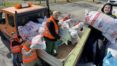 Fleißig wurden wieder alle Kleiderspenden von den ehrenamtlichen Rotkreuzlern am Kreinzel von den Sammlungsfahrzeugen auf den Abrollcontainer des Textilverwerters verladen, bis dieser am Ende der Altkleidersammlung der Bereitschaft Erbendorf im BRK randvoll war. (Bild: Sven Lehner)