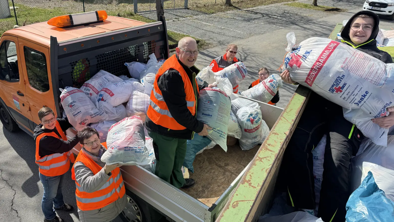Fleißig wurden wieder alle Kleiderspenden von den ehrenamtlichen Rotkreuzlern am Kreinzel von den Sammlungsfahrzeugen auf den Abrollcontainer des Textilverwerters verladen, bis dieser am Ende der Altkleidersammlung der Bereitschaft Erbendorf im BRK randvoll war. (Bild: Sven Lehner)