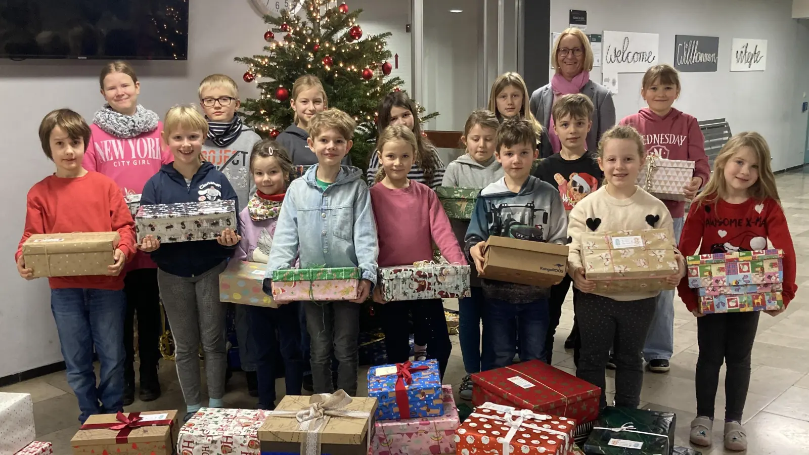 Die Schülerinnen und Schüler präsentieren stolz die vielen Weihnachtspäckchen für Kinder in Not. (Bild: Magdalena Reger)