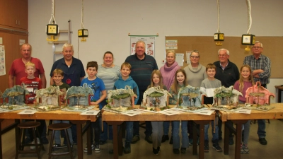 Voller Stolz präsentierten die Kinder am Ende des letzten Kursnachmittags ihre neuen Krippen. Mit auf dem Bild der Kursleiter und Helfer aus den Reihen des Krippenvereins, hinten v. r. Max Blank, Uli Reindl, Manuela Fronhofer, Richard Rauch, Birgitt Pröls, Karin Kraus, Bernhard Büller und Peter Pichl. (Bild: Carolin Kausler)