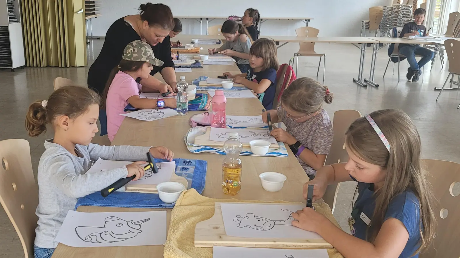 Mit viel Ausdauer und Geschick hämmern die Kinder Nägel entlang der Umrisslinien ihres Motivs. (Bild: Doris Enzmann)