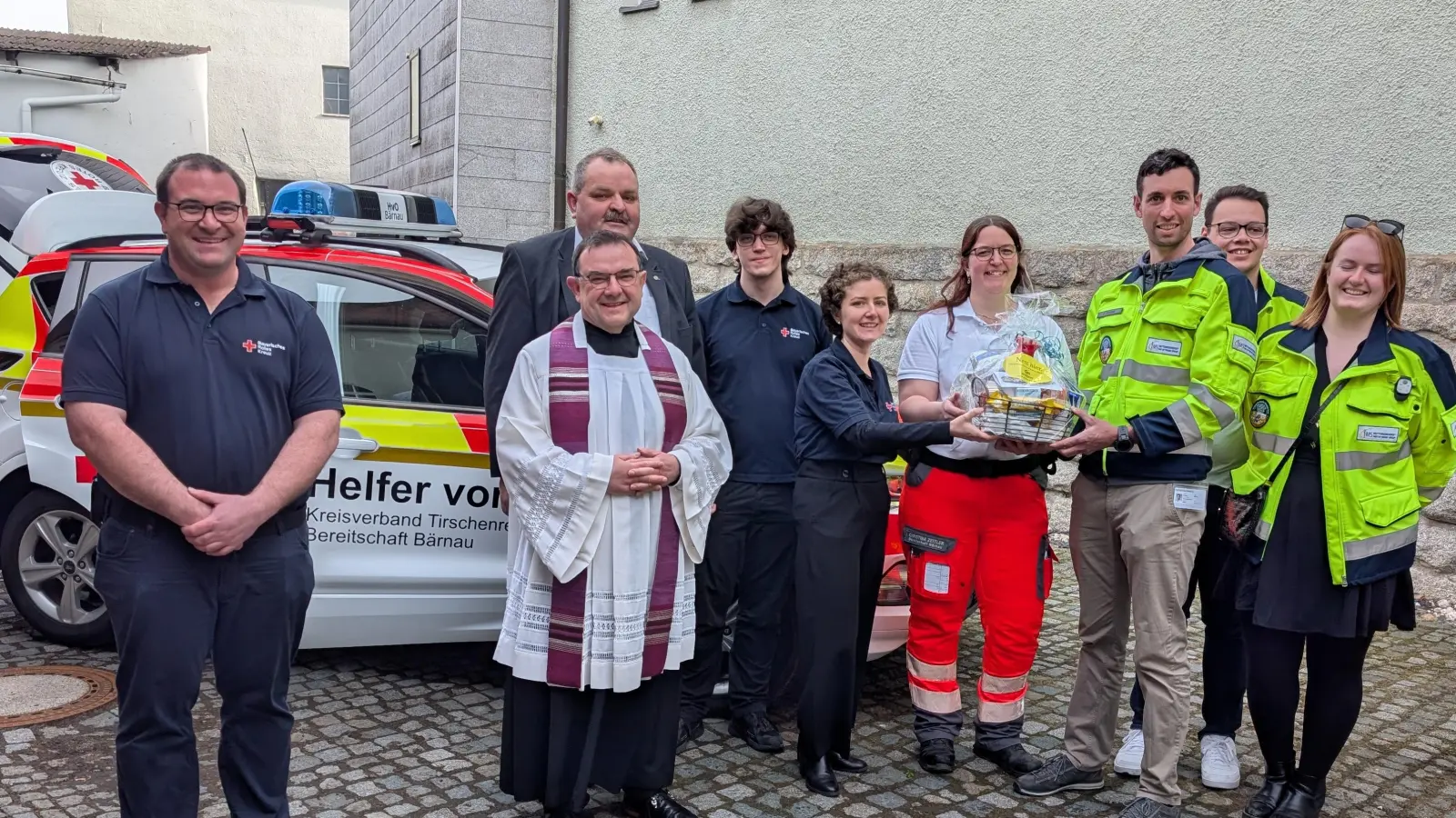 Gruppenbild nach der Segnung des neuen HvO-Autos der Bereitschaft Bärnau mit Bereitschaftsleiter Thomas Wagner, Stadtpfarrer Konrad Amschl, 2. Bürgermeister Michael Schedl, Kollegen des IMS-Rettungsdienstes und dem Team der BRK Bereitschaft Bärnau (Bild: Maria Wagner)