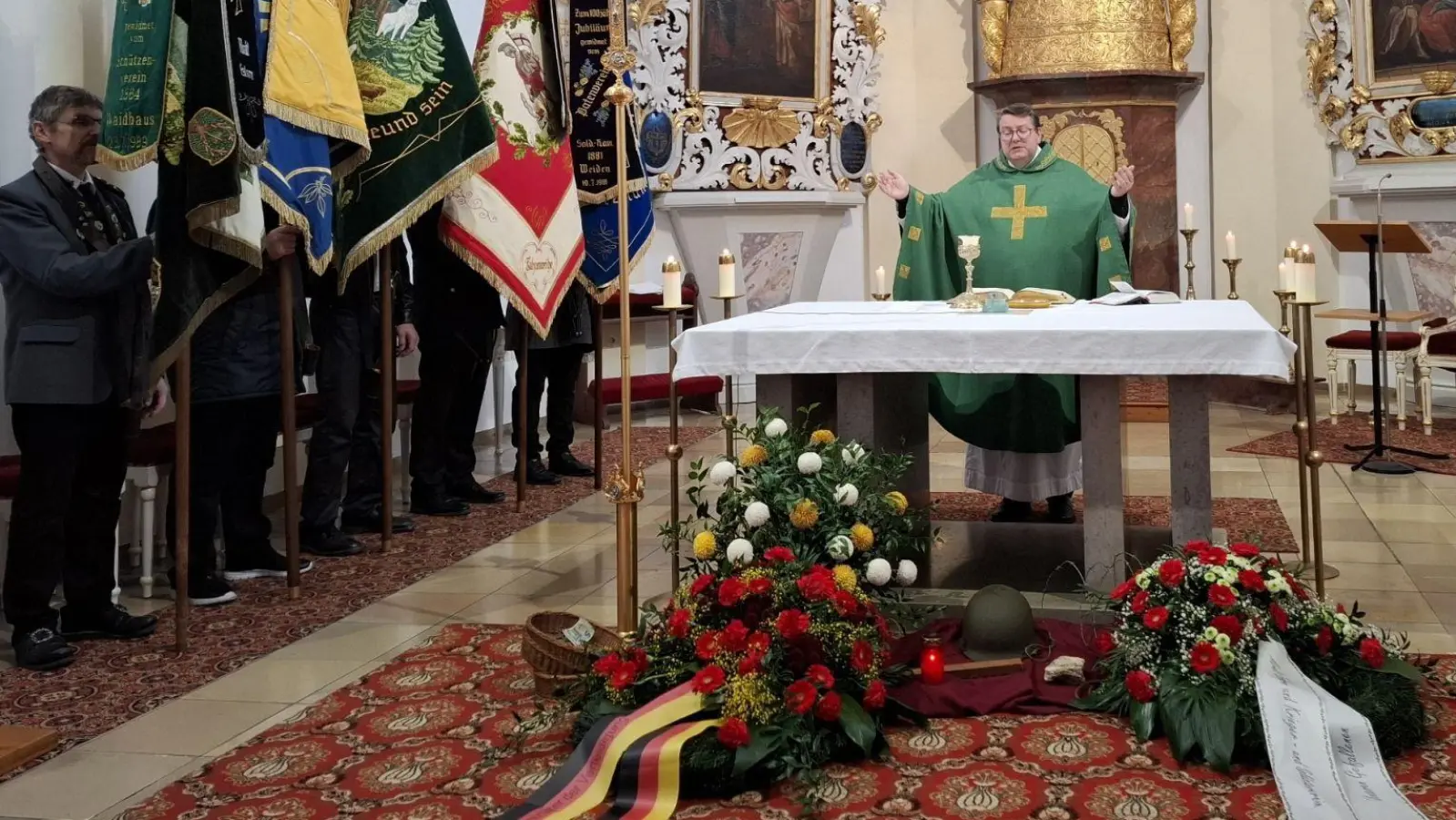 Die Messfeier an Volkstrauertag zelebrierte Pfarrer Udo Klösel und die Fahnenträger platzierten sich neben dem Altar. (Bild: Karl Ziegler)